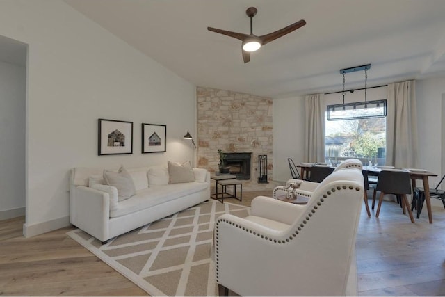 living room featuring ceiling fan, lofted ceiling, and light wood-type flooring