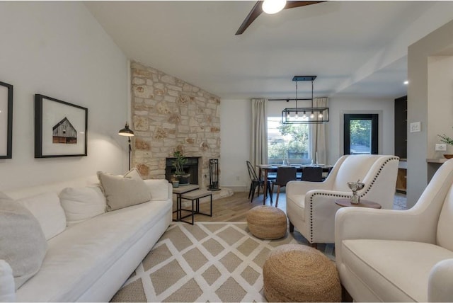 living room with ceiling fan, a fireplace, lofted ceiling, and hardwood / wood-style flooring