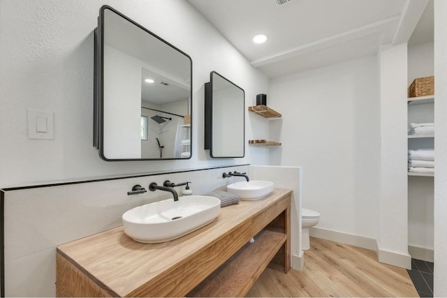 bathroom with walk in shower, toilet, vanity, and hardwood / wood-style flooring