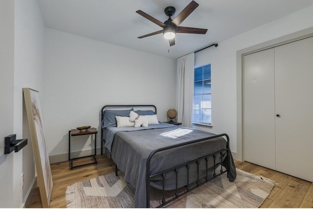 bedroom with ceiling fan, light hardwood / wood-style floors, and a closet