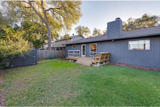 rear view of property featuring a yard and a deck