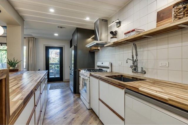 kitchen featuring wood counters, white appliances, sink, decorative backsplash, and light hardwood / wood-style floors