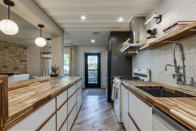 kitchen with butcher block countertops, light hardwood / wood-style floors, white cabinetry, and white gas range oven