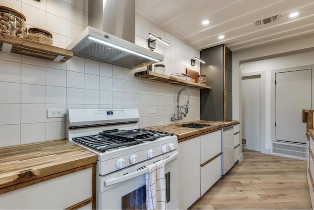 kitchen featuring white appliances, ventilation hood, light hardwood / wood-style flooring, butcher block countertops, and white cabinetry