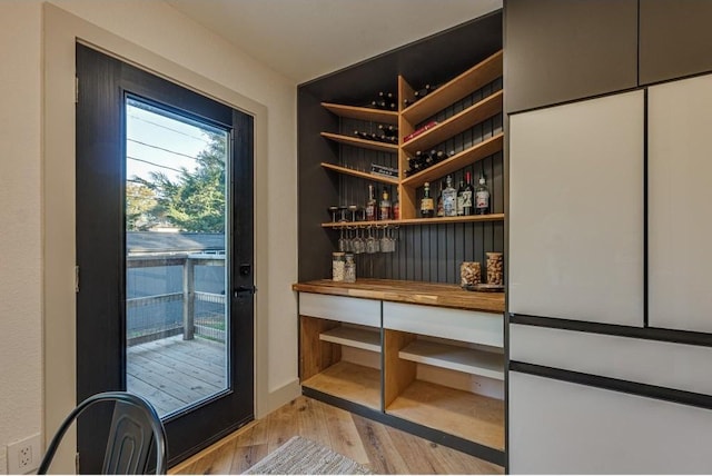 wine area featuring light hardwood / wood-style floors and indoor bar