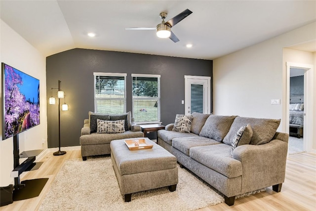 living room with light hardwood / wood-style floors, ceiling fan, and lofted ceiling