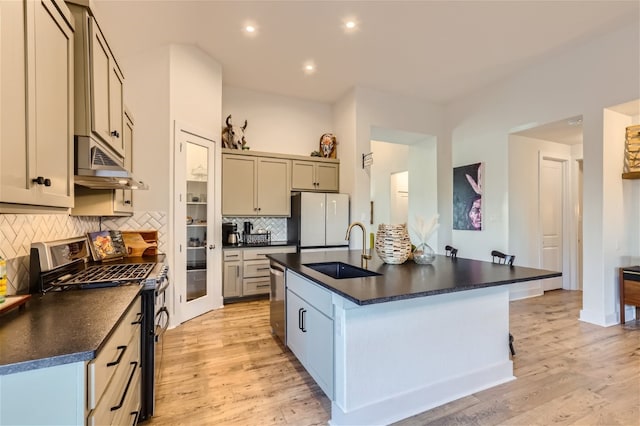 kitchen featuring decorative backsplash, light wood-type flooring, stainless steel appliances, sink, and gray cabinets