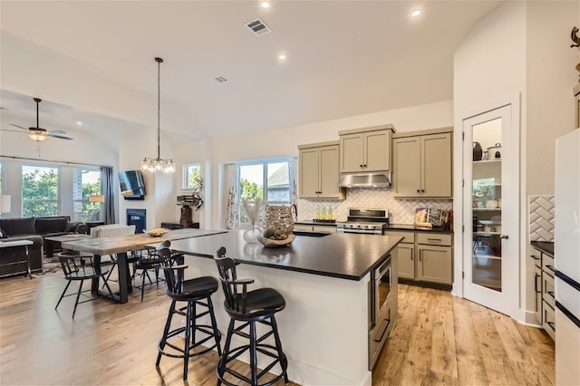 kitchen with plenty of natural light, light hardwood / wood-style flooring, stainless steel range with electric cooktop, and lofted ceiling