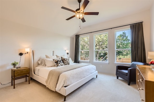 bedroom with ceiling fan, light colored carpet, and vaulted ceiling