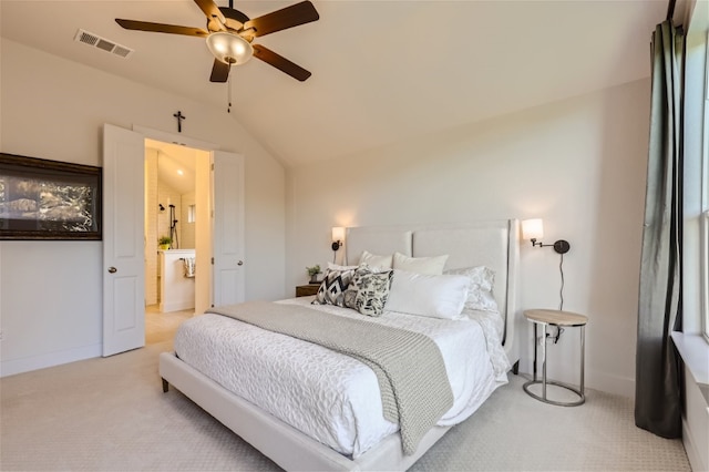 carpeted bedroom with ceiling fan, ensuite bathroom, and vaulted ceiling