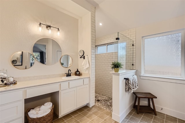 bathroom featuring tile patterned flooring, vanity, and tiled shower