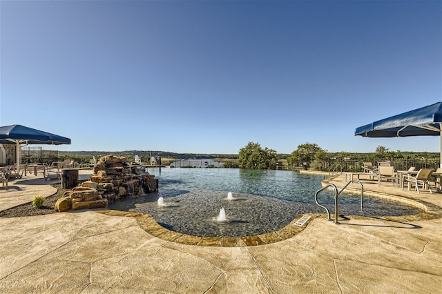 view of pool featuring a patio area and a water view