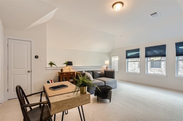 interior space with light carpet and vaulted ceiling