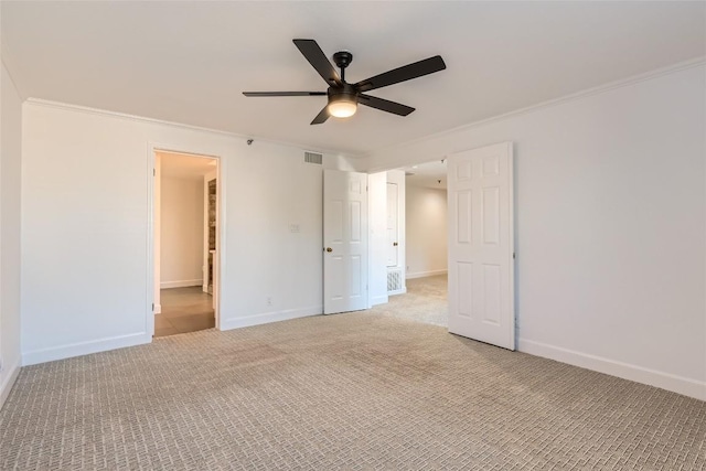 unfurnished bedroom featuring ceiling fan, crown molding, and light colored carpet