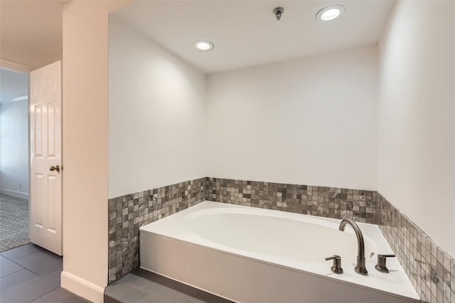 bathroom featuring tile walls, a washtub, and tile patterned floors