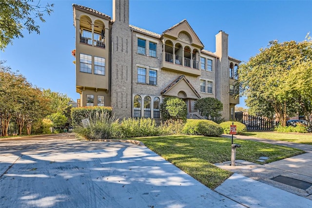 view of front of house with a front yard and a balcony