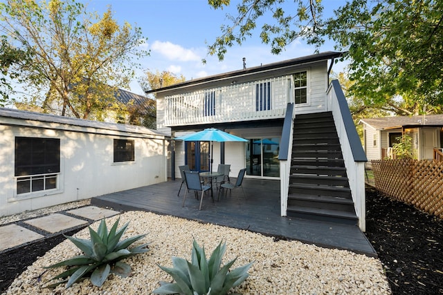 back of property with a deck and an outdoor structure