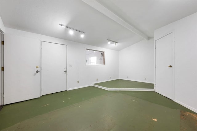 below grade area with rail lighting and baseboards