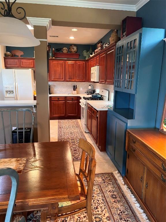 kitchen featuring white appliances, ornamental molding, tasteful backsplash, and light tile patterned flooring