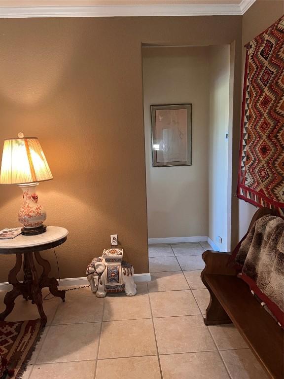 corridor with crown molding and light tile patterned flooring