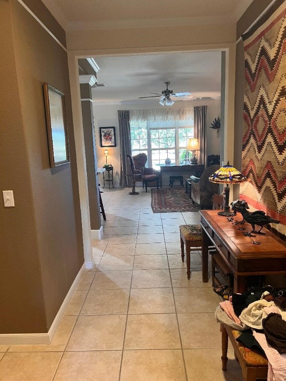 hallway with crown molding and light tile patterned floors