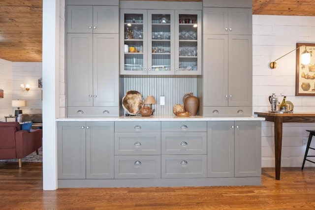 bar with gray cabinets, hardwood / wood-style floors, and wooden ceiling