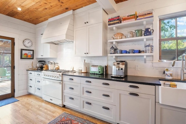 kitchen with wooden ceiling, light wood-type flooring, custom range hood, high end white range oven, and white cabinets