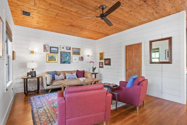 living room featuring dark wood-type flooring, wooden ceiling, and ceiling fan