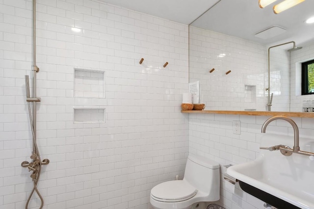 bathroom with sink, tile walls, and toilet