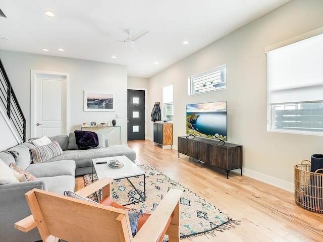 living room featuring light hardwood / wood-style floors and ceiling fan