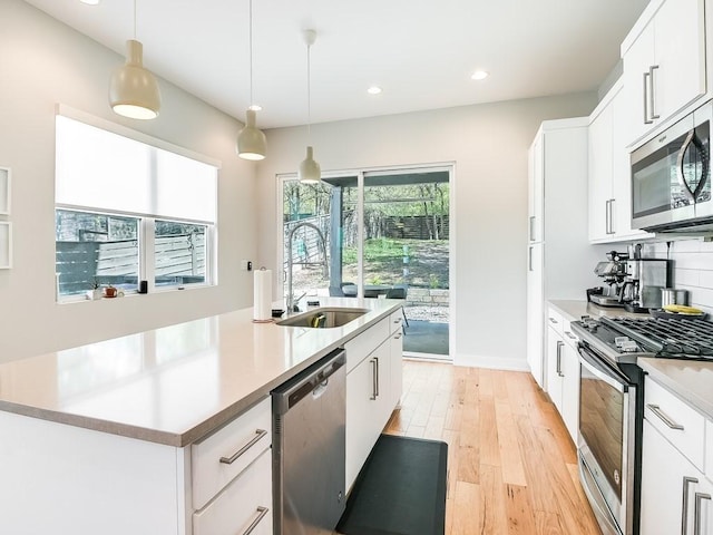 kitchen with white cabinetry, sink, an island with sink, and stainless steel appliances