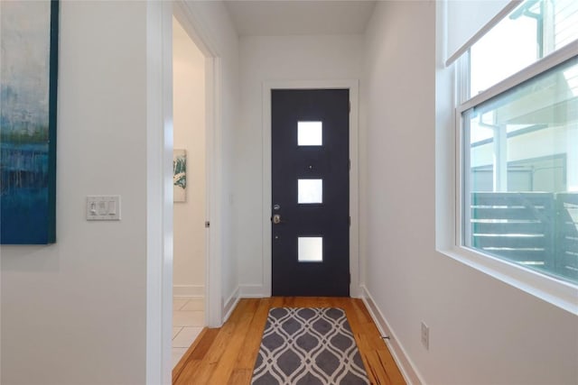 1211 Cometa St Unit B, Austin, TX 78721 - doorway to outside featuring light wood-type flooring, plenty of natural light, and baseboards