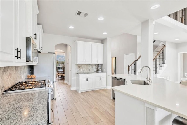 kitchen with appliances with stainless steel finishes, white cabinets, and sink