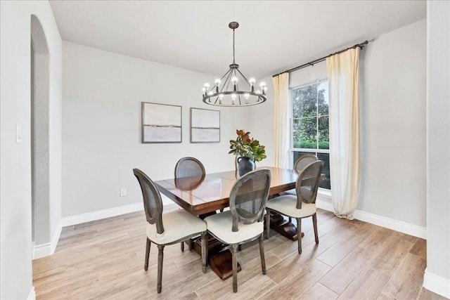 dining room with an inviting chandelier and light hardwood / wood-style flooring