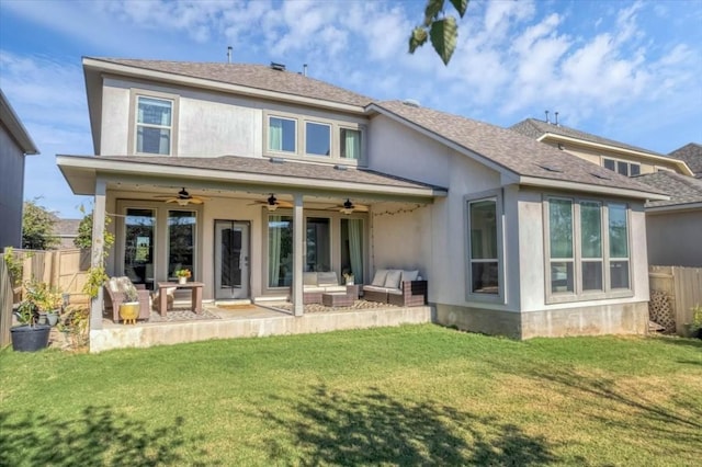 rear view of property featuring ceiling fan, a patio area, outdoor lounge area, and a yard