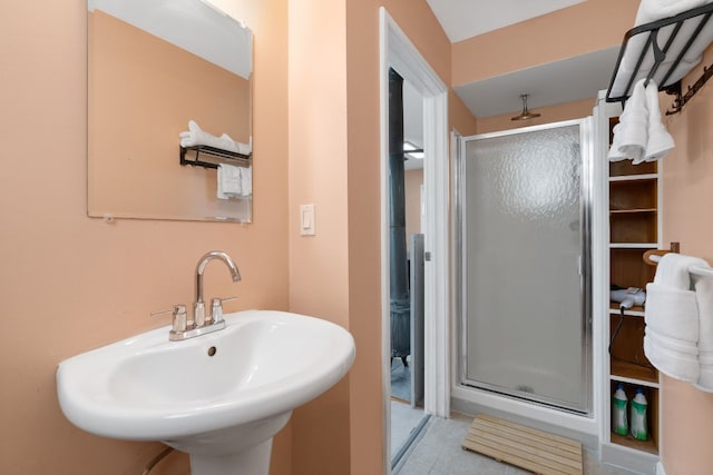 bathroom featuring tile patterned floors, a shower with door, and sink