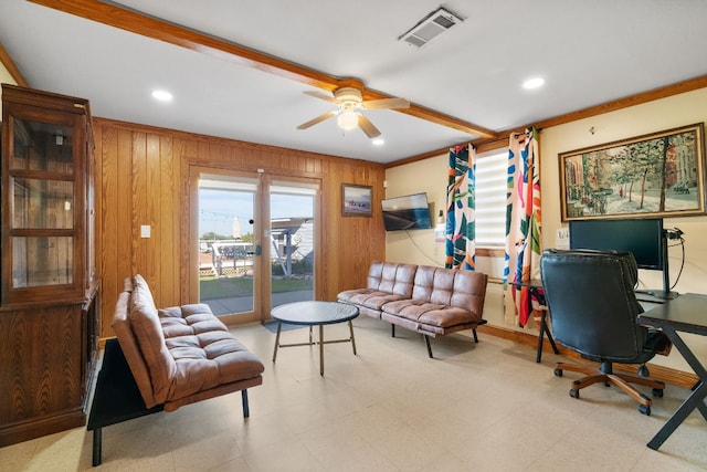 home office with ceiling fan, crown molding, and wooden walls