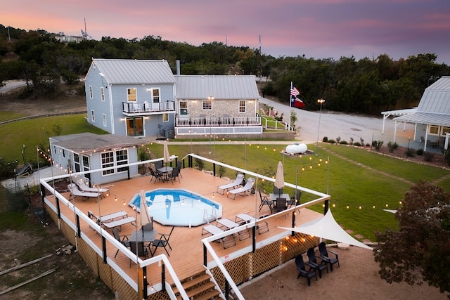 back house at dusk featuring a fenced in pool