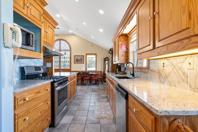 kitchen featuring backsplash, exhaust hood, sink, vaulted ceiling, and appliances with stainless steel finishes