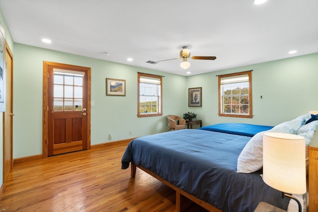 bedroom featuring multiple windows, ceiling fan, and light wood-type flooring