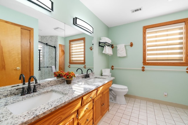 bathroom with toilet, a shower with door, vanity, and tile patterned flooring