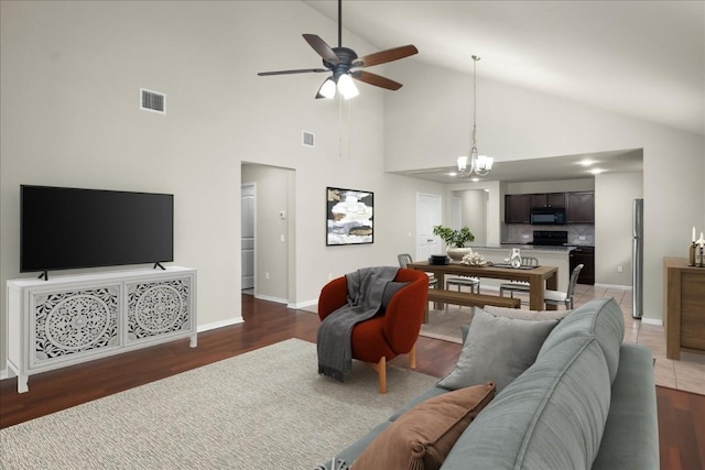 living room featuring ceiling fan with notable chandelier, dark hardwood / wood-style floors, and high vaulted ceiling