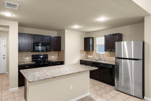 kitchen with black appliances, a center island, light tile patterned floors, and sink