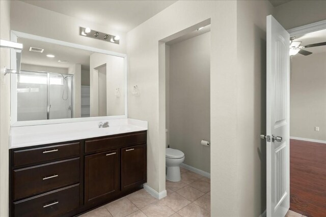 bathroom with hardwood / wood-style floors, vanity, ceiling fan, toilet, and a shower with shower door