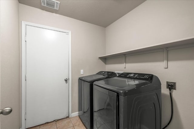 washroom with light tile patterned flooring and washing machine and dryer