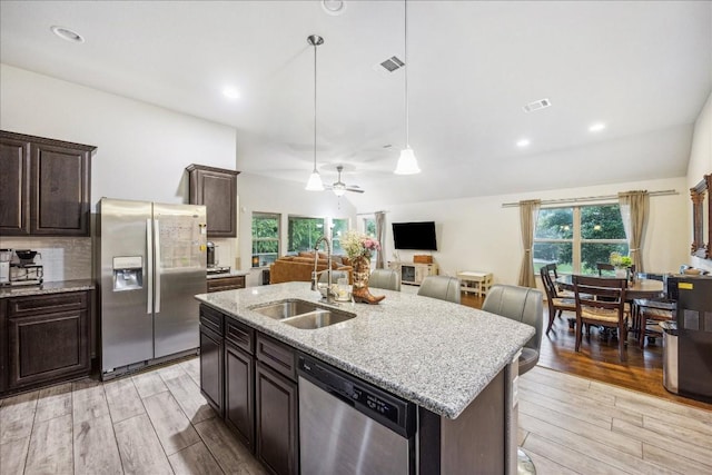 kitchen featuring sink, stainless steel appliances, a center island with sink, and light hardwood / wood-style flooring