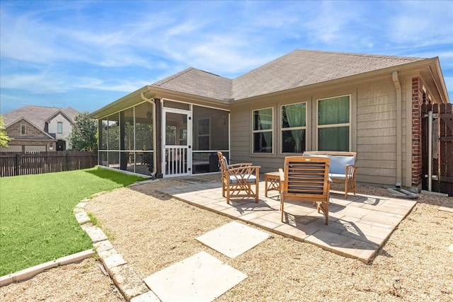 back of property with a sunroom, an outdoor living space, a patio area, and a lawn