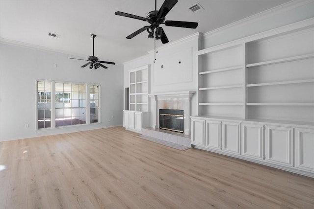 unfurnished living room featuring ceiling fan, crown molding, a fireplace, and light hardwood / wood-style flooring