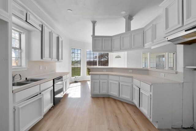 kitchen featuring stainless steel dishwasher, white cabinets, sink, and a wealth of natural light