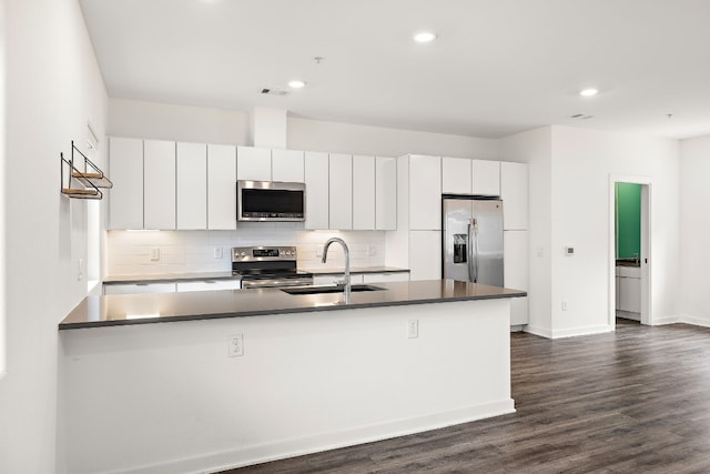 kitchen featuring tasteful backsplash, white cabinetry, appliances with stainless steel finishes, and sink